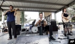 FILE - Savoy family members, Joel Savoy on fiddle, his father, Marc Savoy, on accordion and mother, Ann Savoy, play traditional Cajun music mixed with some contemporary tunes at the Festivals Acadiens in Lafayette, Louisiana, Sept. 17, 2005.