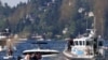 Seattle Fire Department personnel, police officers and civilians search for a missing swimmer who possibly drowned in Andrews Bay of Lake Washington, at Seward Park during a heat wave in Seattle, Washington, June 26, 2021.