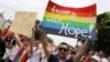 FILE - A group of Russian gays, seeking asylum in Germany because of their sexual orientation, take part in the annual Christopher Street Day gay parade in Cologne, Germany, July 5, 2015.