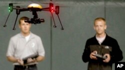 Students at John D. Odegard School of Aerospace Sciences at the University of North Dakota in Grand Forks, North Dakota, remotely pilot a drone during a demonstration, in a June 24, 2014, photo.