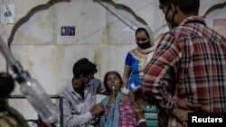 Seorang perempuan dengan masalah pernapasan menerima bantuan oksigen gratis di Gurudwara (kuil Sikh), di tengah penyebaran COVID-19, di Ghaziabad, India, 24 April 2021. (Foto: Reuters)