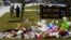 A student is consoled after he placed flowers on a memorial at the entrance to Newtown High School in Newtown, Connecticut December 18, 2012. 