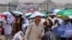 Para jemaah haji berjalan dengan payung di tengah cuaca yang sangat panas, di Mina, Arab Saudi, 18 Juni 2024. (Foto: REUTERS/Saleh Salem)