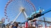 People wait in line to board rides at Gillian's Wonderland, the popular amusement park on the boardwalk in Ocean City, N.J., during its final day of operation before shutting down for good, Oct. 13, 2024.