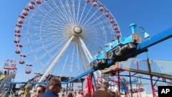 People wait in line to board rides at Gillian's Wonderland, the popular amusement park on the boardwalk in Ocean City, N.J., during its final day of operation before shutting down for good, Oct. 13, 2024.