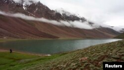 Tourists look at clouds hanging over Chandra Taal Lake in the Lahoul & Spiti district, in the northern Indian state of Himachal Pradesh, July 15, 2009. 