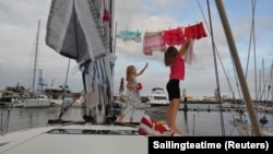 Katalin Bosze and Boroka Bosze hang their clothes to dry on the sailing boat 'Teatime' in Las Palmas, Spain. Picture taken on October 5, 2020. (Sailingteatime via Reuters)