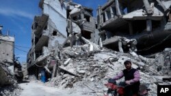 A man rides past destruction in the town of Douma, the site of a suspected chemical weapons attack, near Damascus, Syria, April 16, 2018. 