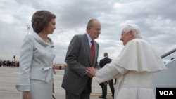 Paus Benediktus XVI (kanan) disambut oleh Raja Spanyol Juan Carlos dan Ratu Sofia saat tiba di bandara Madrid (18/8).