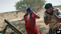 Revolutionary fighters firing a mortar at Gadhafi loyalist positions in Sirte, Libya, Monday, Sept. 19, 2011