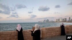 Israeli Arab women overlook the Mediterranean sea, in the mixed Arab Jewish city of Jaffa, near Tel Aviv, Israel, Sept. 23, 2019.