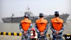 Soldiers from the Chinese People's Army Navy watch as the USS Blue Ridge arrives in Shanghai, May 6, 2016. China recently denied a request for USS John C. Stennis to visit Hong Kong, in an apparent sign of mounting tensions.