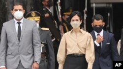 Maria Alejandra Muñoz, nueva vicepresidenta de Ecuador, es escoltada por el vicepresidente de la Asamblea, César Solórzano, izquierda, y su esposo Leopoldo Orellana, mientras dejan la Asamblea Nacional después de su juramentación en Quito, Ecuador.
