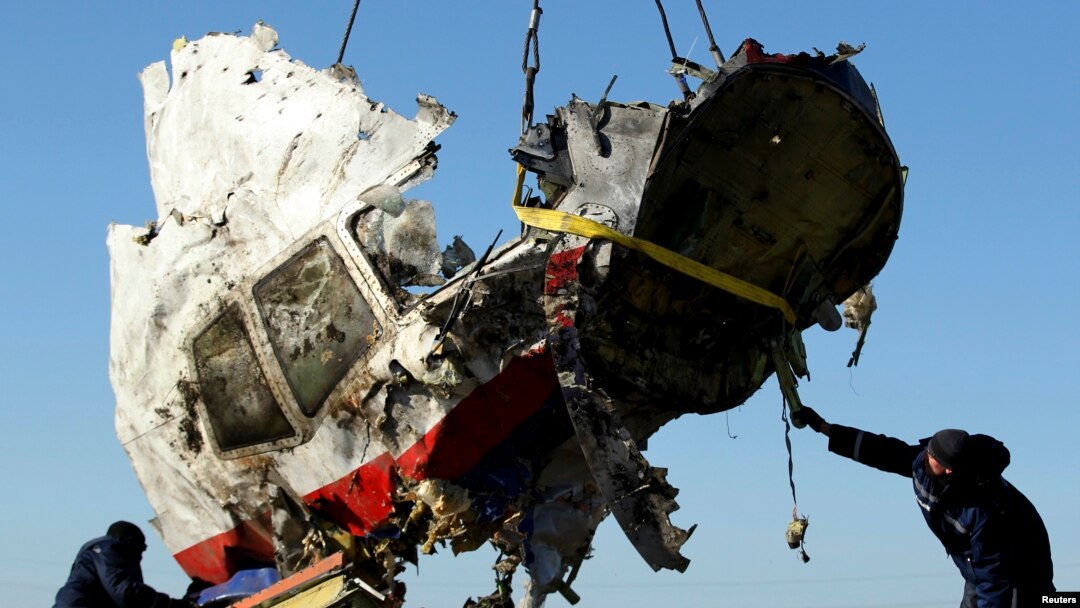 FILE - Local workers haul away a piece of wreckage of Malaysia Airlines flight MH17 at the site of the plane's crash near the village of Hrabove, Donetsk region, eastern Ukraine, Nov. 20, 2014.