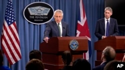 Defense Secretary Chuck Hagel, accompanied by British Defense Secretary Philip Hammond, addresses reporters following talks at the Pentagon, near Washington, May 2, 2013.