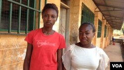 Elizabeth Issa (à gauche) se tient avec une autre étudiante en dehors d'une école proposant des cours pour les femmes enceintes et jeunes mamans à Freetown, Sierra Leone, le 22 février 2016. (Photo: Nina deVries pour VOA)