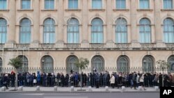 People wait outside the former royal palace to pay respects to the late Romanian King Michael in Bucharest, Romania, Dec. 14, 2017. 