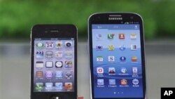 ໂທລະສັບມືຖື Samsung Electronics' Galaxy S III (R) ແລະ Apple's iPhone 4S ທີ່ວາງຂາຍຢູ່ຮ້ານຄ້າແຫ່ງນຶ່ງ ໃນກຸງໂຊລ.