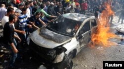 Civil defence members and civilians put out a fire at the site of an explosion in the southern suburbs of Beirut, Feb. 19, 2014.