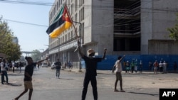 A man holds a Mozambican flag as members of the Islamic community of Mozambique march during a protest against the results of the 2024 presidential elections in Maputo on November 2, 2024.