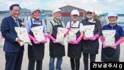 미셸 스틸 대사(오른쪽 세 번째)가 19일 곡성군 석곡농협 재배단지에서 열린 `벼 수확' 행사에서 참석자들과 백세미를 들고 기념촬영을 하고 있다. (출처: 전남광주시) 