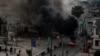 Armed men are seen near burning tires on a street in Lagos, Nigeria Oct. 21, 2020, in this image obtained from social media. (Credit: UnEarthical)