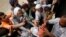 FILE - People gather to collect food rations at a food distribution center in Sana'a, Yemen, March 21, 2017.