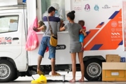 FILE - Health workers collect nasal swabs from locals for coronavirus testing at a mobile facility in Bangkok, Thailand, Aug. 4, 2021.