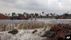 Warga setempat melewati jalanan yang rusak akibat banjir di wilayah Hyderabad, negara bagian Andhra Pradesh di selatan India  (26/10).