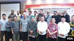 Gubernur Jateng, Ganjar Pranowo (depan ke-4 dari kiri) beserta rombongan Pemprov Jateng foto bersama mantan napi terorisme, Joko Tri, ketua Yayasan Gema Salam (depan nomor 5 dari kiri) di salah satu hotel di Solo, Jumat (28/6). (VOA/Yudha)