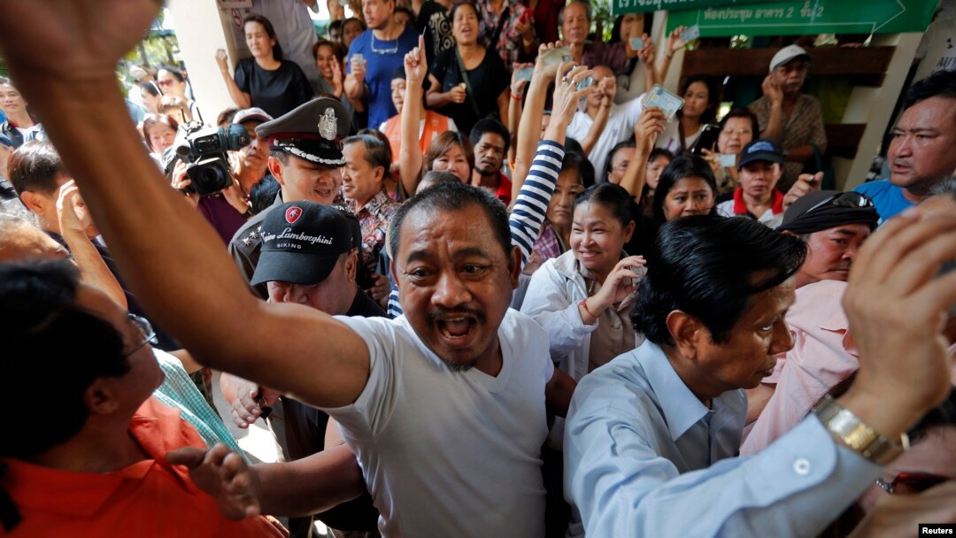 Para demonstran menuntut hak memberikan suara bertengkar dengan petugas TPS di distrik Din Dang tempat pemungutan suara dibatalkan di Bangkok (2/2). (Reuters/Damir Sagolj)