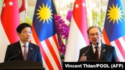 Perdana Menteri Malaysia Anwar Ibrahim (kanan) dan Perdana Menteri Singapura Lawrence Wong (kiri) menghadiri konferensi pers di kantor Perdana Menteri di Putrajaya pada 7 Januari 2025. (Foto: Vincent Thian/POOL/AFP)