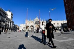 Tourists walk in St. Mark's Square in Venice, Italy, Feb. 28, 2020.