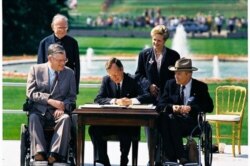 President George H. W. Bush signs the Americans with Disabilities Act of 1990 into law. Pictured (left to right): Evan Kemp, Rev Harold Wilke, Pres. Bush, Sandra Parrino, Justin Dart. July 26, 1990.