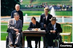 President George H. W. Bush signs the Americans with Disabilities Act of 1990 into law. Pictured (left to right): Evan Kemp, Rev Harold Wilke, Pres. Bush, Sandra Parrino, Justin Dart. July 26, 1990.