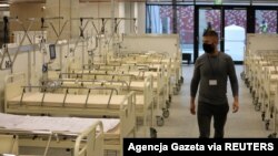 FILE - A man walks inside PGE National Stadium where the Polish government built a special field hospital for people infected with the coronavirus disease in Warsaw, Poland, Oct. 29, 2020.