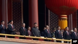 FILE - Chinese President Xi Jinping, center, stands with other Chinese leaders to watch a parade as Communist Party celebrates its 70th anniversary in Beijing, Oct. 1, 2019. 