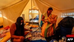 Migrantes venezolanos se sientan en una carpa instalada en el Puente Internacional Tienditas en Cúcuta, Colombia, en la frontera con Venezuela, esperando una oportunidad para regresar a su país. 