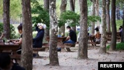 People rest as they keep social distancing to avoid the spread of the coronavirus disease (COVID-19) at a park in Seoul, South Korea, September 27, 2021. REUTERS/Kim Hong-Ji