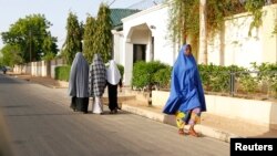 Wasu mata na wucewa a wata unguwa cikin Maiduguri, inda ake aiki da dokar ta baci, Lahadi 19 Mayu, 2013