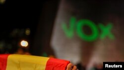 FILE - A supporter of Spain's far-right party Vox holds a Spanish flag during a campaign closing rally ahead of the general election, at Colon square in Madrid, Spain, Nov. 8, 2019. 