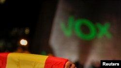 FILE - A supporter of Spain's far-right party Vox holds a Spanish flag during a campaign closing rally ahead of the general election, at Colon square in Madrid, Spain, Nov. 8, 2019. 