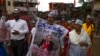 A group of people raise slogans opposing redevelopment of Dharavi, one of Asia's largest slums, through the Adani Group during a protest in Mumbai, India, Aug. 9, 2023. The protestors are demanding that the government withdraw the project from Adani. 