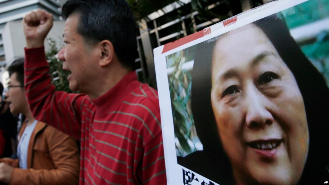 FILE - Anti-Beijing protesters hold picture of veteran Chinese journalist Gao Yu during a rally outside Chinese central government's liaison office in Hong Kong.
