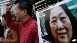 FILE - Anti-Beijing protesters hold picture of veteran Chinese journalist Gao Yu during a rally outside Chinese central government's liaison office in Hong Kong.