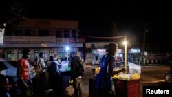 A street vendor sells food as Uganda reopens its bars and night clubs after nearly two years of restrictions to curb the spread of coronavirus disease (COVID-19), in Jinja, Uganda, Feb. 2, 2022. 