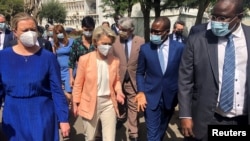 FILE - European Commission President Ursula von der Leyen speaks to officials during a tour of the Pasteur Institute vaccination and testing facility, in Dakar, Senegal, Feb. 9, 2022. 