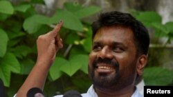 Anura Kumara Dissanayake, the presidential candidate from National People's Power, shows his ink-marked finger after casting his vote at a polling station, on the day of the presidential election, in Colombo, Sri Lanka, Sept. 21, 2024.