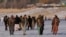Taliban fighters walk at the frozen Qargha Lake, near Kabul, Afghanistan, Feb. 11, 2022. The Taliban have released from custody two foreign journalists and their local colleagues after "verifying their identities."
