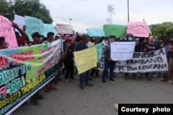 Massa Aksi Aliansi Masyarakat Tani Peduli membentangkan spanduk menolak tambang emas dalam aksi demonstrasi di desa Siney, Kecamatan Tinombo Selatan, Kabupaten Parigi Moutong, Sulawesi Tengah, pada 12 Februari 2022. (Foto: Humas Polda Sulteng)